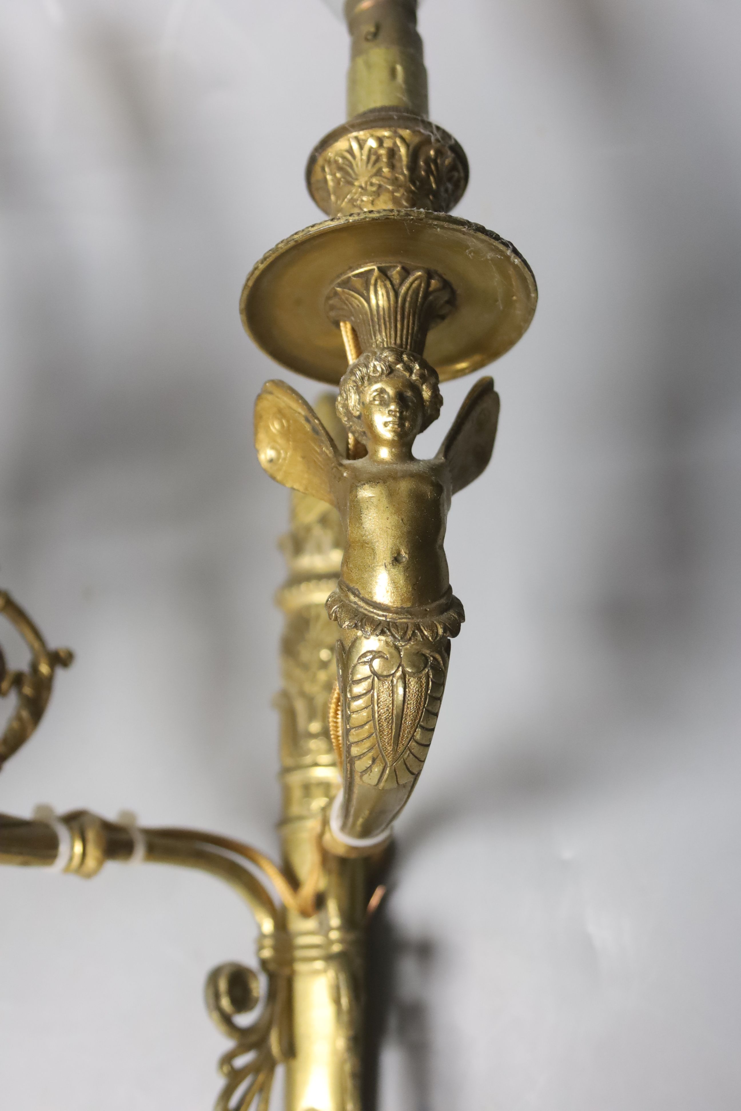 A pair of two branch ormolu wall lights with cherubs, height 42cm